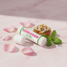 Load image into Gallery viewer, Beeblegum Lip Care balm on pink marble with rose petals and natural ingredients
