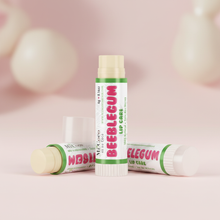 Load image into Gallery viewer, Three Beeblegum Lip Care balms arranged as a group on pastel pink surface
